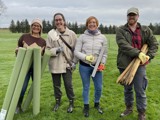 [Four NEPO staff members in field at Stamfordham on a tree planting day. They are holding various pieces of equipment ]needed to plant trees]